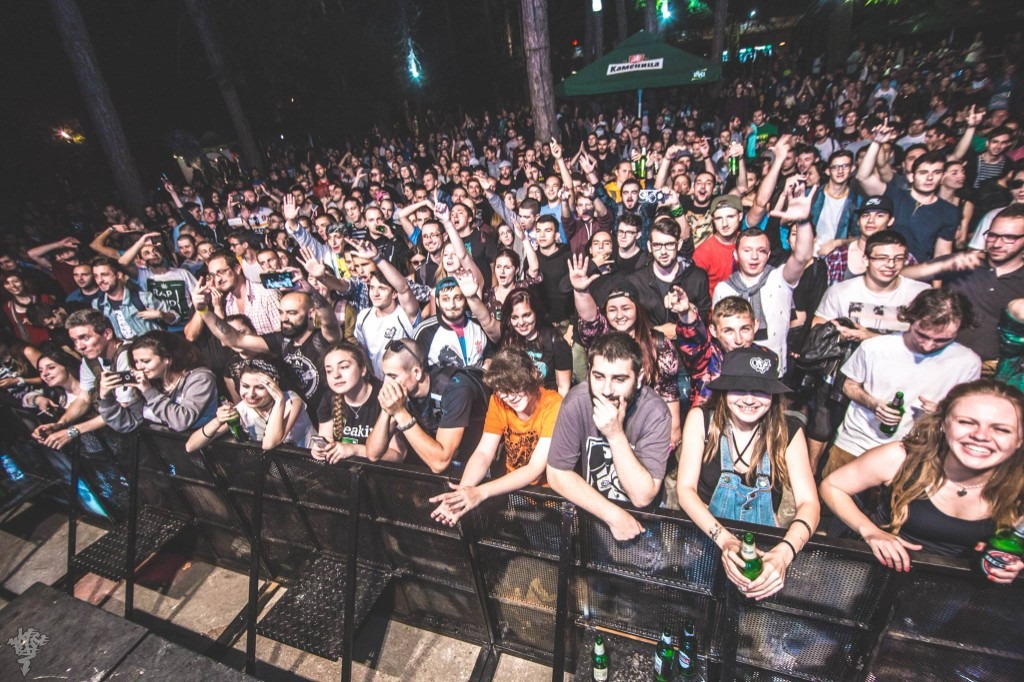 Публика зад бариера на нощен концерт на открито